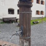 Engadine, Scuol, Val S-charl, village square with Bear Fountain, with Organizational Science AG Logo
